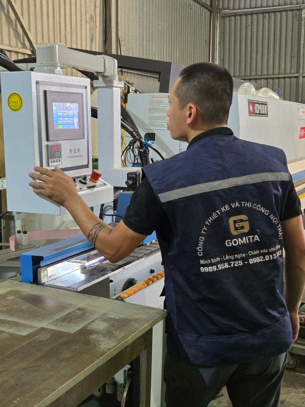 Thợ GOMITA điều khiển máy dán cạnh tại xưởng